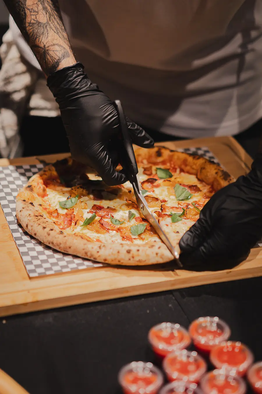Pizza Origin con pesto de albahaca y tomates cherry confitados, recién cortada