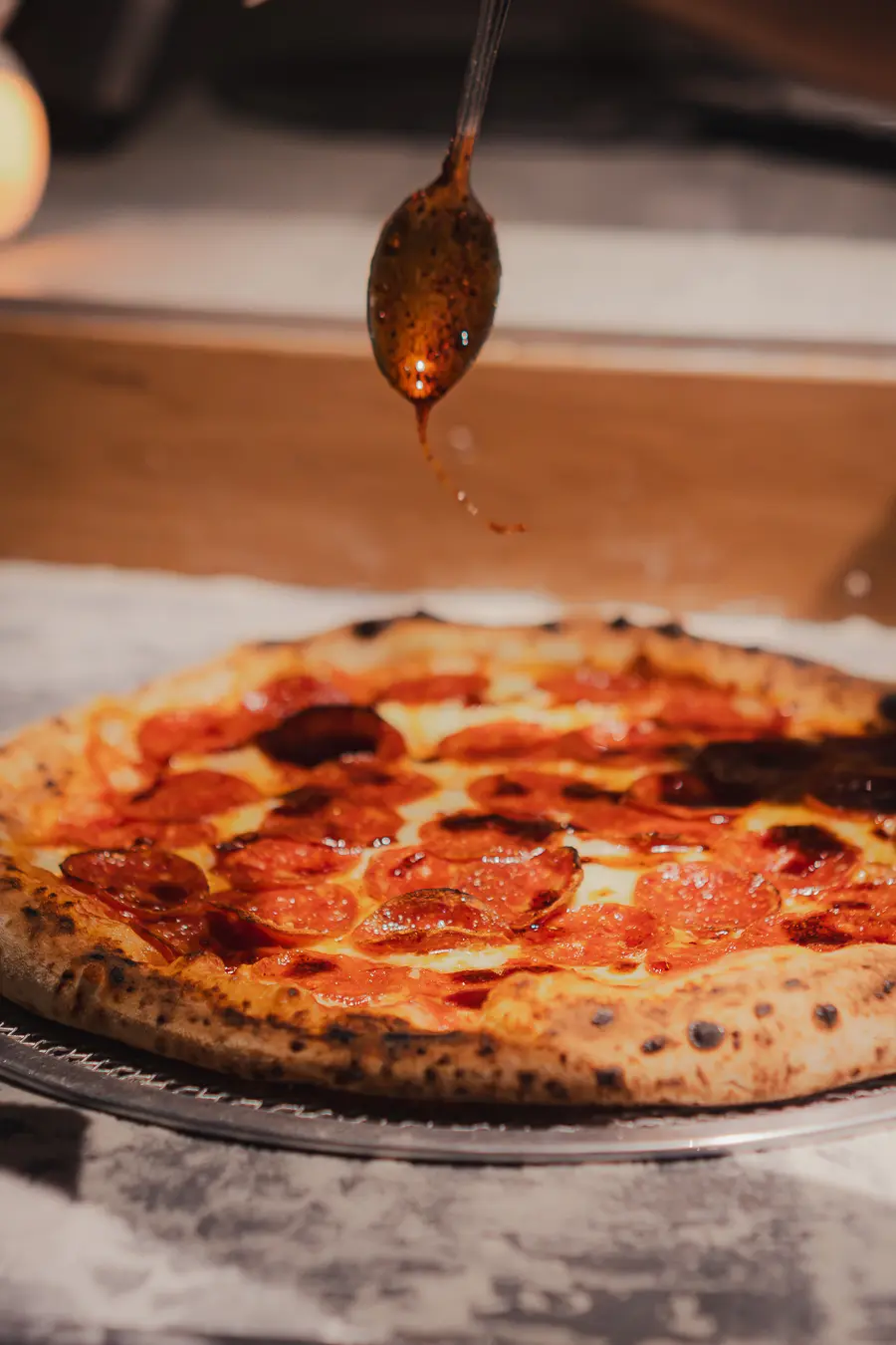 Pizza Red Smoke recibiendo un hilo de miel infusionada con merkén