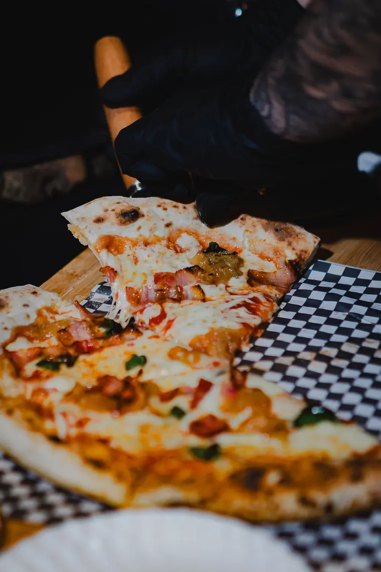 Pizza cortada en porciones sobre la tabla