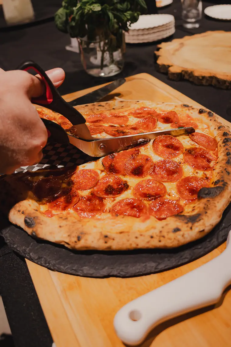 Pepperoni cortado con tijera de pizza